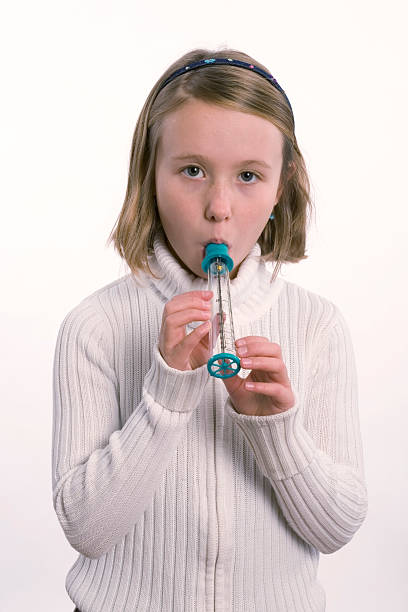 istock Girl with asthma blowing into PEF Meter 115750858