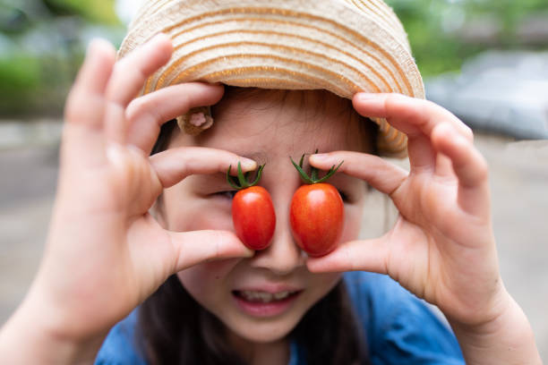 istock Girl holding a tomato 1157512777
