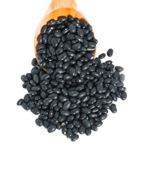 istock black beans with wooden spoon on white background 1157517066