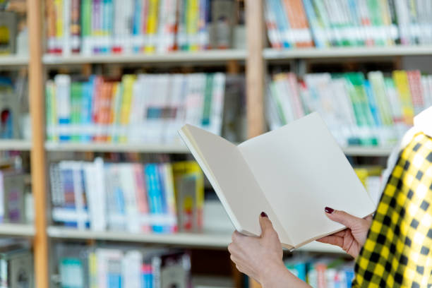 Woman hand holding a blank book in the library.