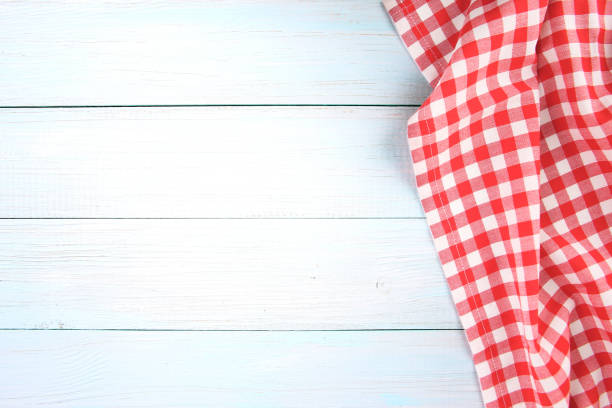 istock Red checked picnic towel cloth on blue wooden empty space background. 1157518351