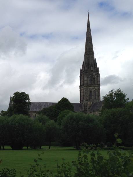 istock Salisbury Cathedral’s spire amongst trees and clouds 1157520847