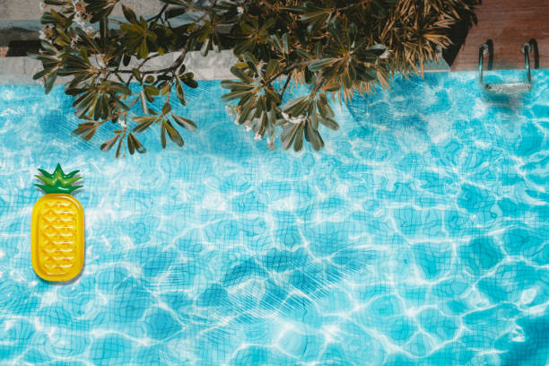 istock Pool float, ring floating in a refreshing blue swimming pool with palm tree leaf shadows in water. Top View 1157523123
