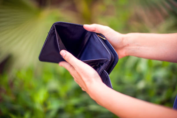 istock Woman holds an empty wallet in hands. Finance problem concept 1157525675