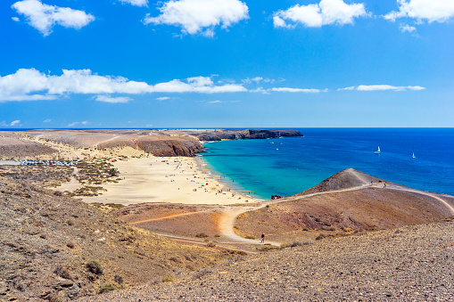 Wide-angle view of Playa Mujeres and Playas del Papagayo, in the southernmost corner of Lanzarote, a perfectly clear sky, dazzling light, iridescent waters, boats sailing in the opal blue ocean. Developed from RAW.