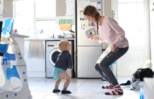 istock Mom and toddler dancing in the kitchen. 1157528049