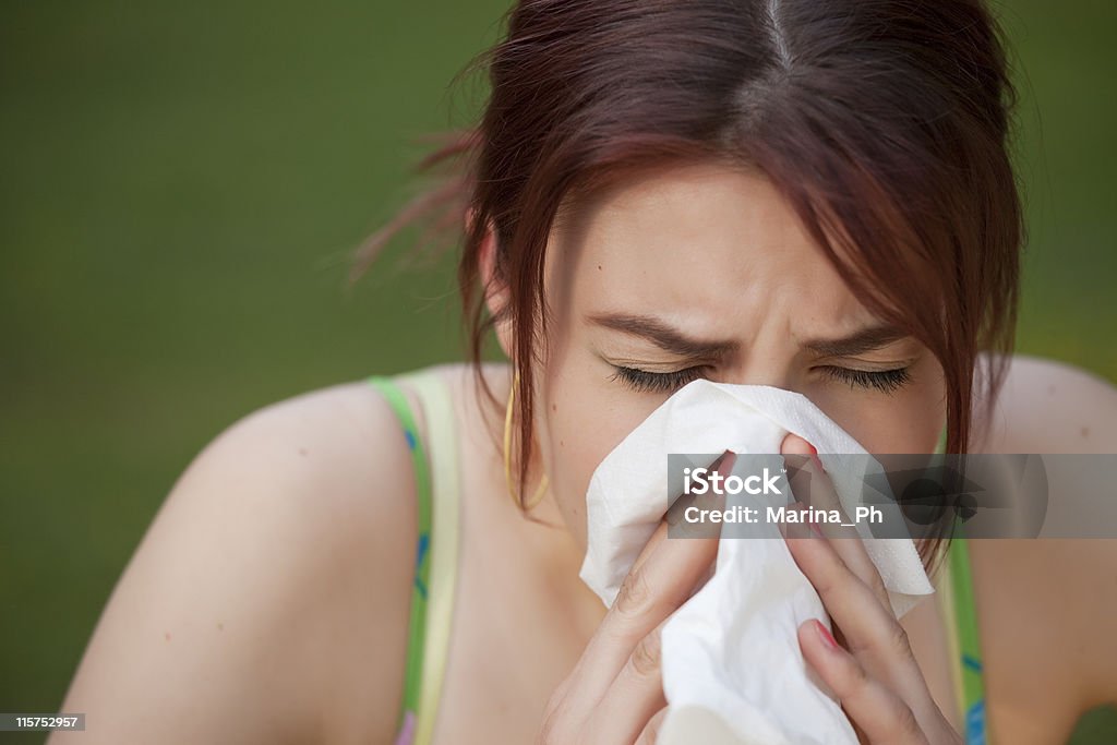 sneezing woman young woman with a an allergy sneezing into her handkerchief Adult Stock Photo