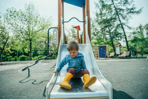 Child sliding on playground in summer