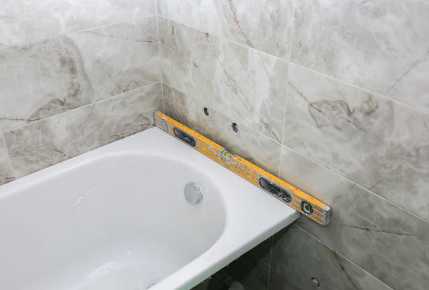 istock Bath installation. Measures with spirit level. Maintenance repair in the flat. Renovation process. 1157535028
