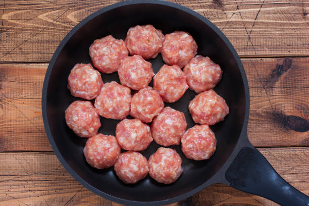 istock Step by Step Cooking Meatballs with Rice in Tomato Sauce with Vegetable Salads - Step 3 - Forming Raw Meatballs, Top View, Horizontal 1157542773