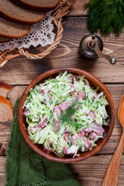 istock Salad with fresh cabbage and smoked sausage on a wooden table, top view, selective focus 1157542920