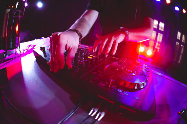DJ playing and mixing music at party Club, disco DJ playing and mixing music for crowd of happy people. Nightlife, concert lights, flares. dj photos stock pictures, royalty-free photos & images