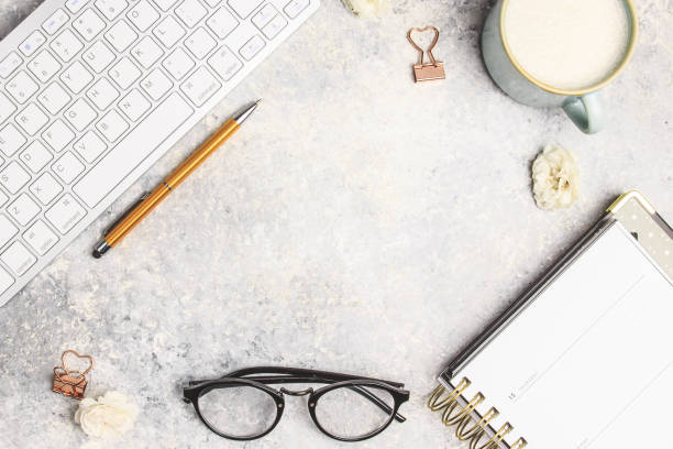 istock Flat lay home office desk. Female workspace with computer keyboard, latte and glasses 1157549000