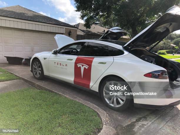 Tesla Repair Technician Car In Driveway Doing Repair Stock Photo - Download Image Now