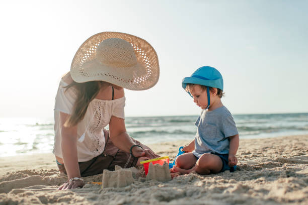 istock Mother and son on the beach playing with sand 1157552935