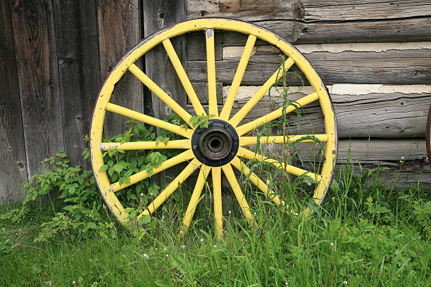 Yellow wagon wheel, Barkerville Historic Town, British Columbia. The community of Barkerville was born in 1862 as the result of a gold miner named Billy Barker striking a rich mother lode in the gravel of Williams Creek. Barkerville is located in the Cariboo Mountains 80 km east of Quesnel, BC, Canada. quesnel stock pictures, royalty-free photos & images