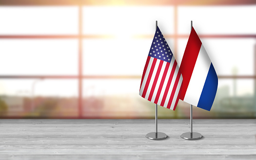 Flags of USA and Ukraine on black table against white background close up