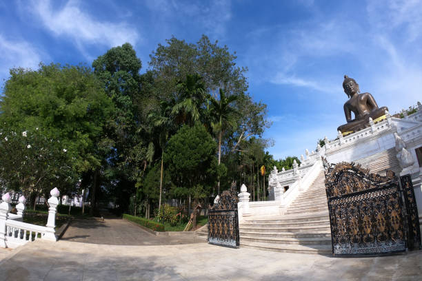 istock Buddha statue in temple with blue sky background. 1157555259