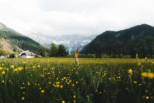 Woman walking on the flower meadow with mountain view in Slovenia
