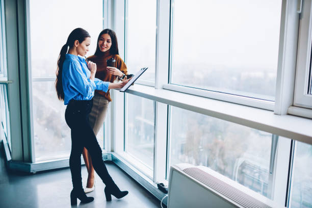 istock Female colleagues discussing plans for startup share opinions standing in loft interior office,manager meeting with confident executive communicating about project and consulting about solutions 1157559511