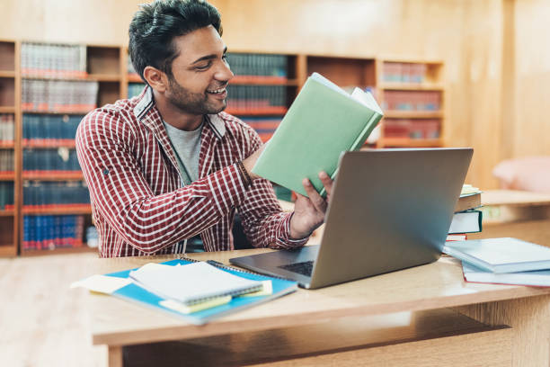 istock University student researching books in a library 1157560044
