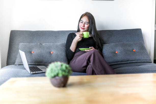 istock Young female freelancer working with laptop at home and drink coffee 1157563162