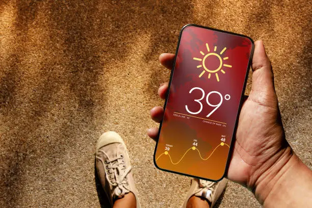 Ecology and Technology Concept. High Temperature Weather show on Mobile Screen on Hot Sunny Day. Top View, Grunge Dirty Concrete Floor with Sunlight as background