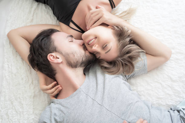 Young couple kissing in the bed .loving couple in bedroom stock photo