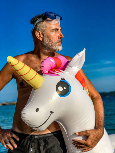 istock Mature Man on Summer Vacations With His Unicorn Pool Raft 1157568470