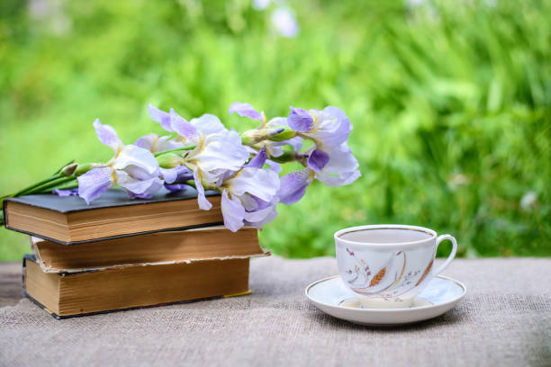 istock A stack of old books, purple irises and a cup of tea 1157568910