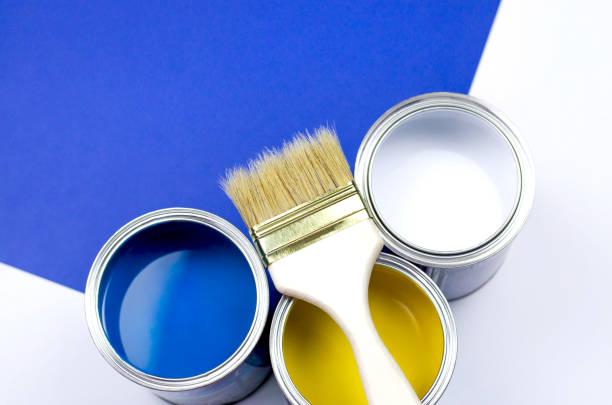 istock Wooden brush with three multi-colored cans of paint. 1157569704