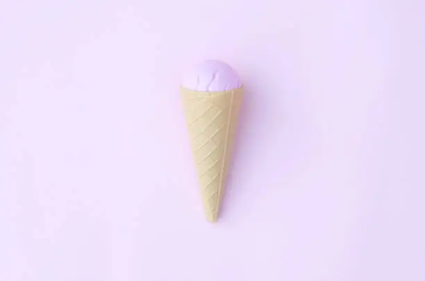 Photo of Toy ice cream cone on a pink background.