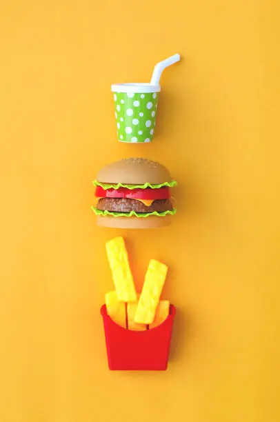 Photo of Toy fastfood food and drink on an orange background.