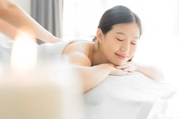 Photo of Young Asian woman  in spa salon getting massage.