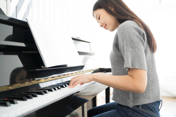 porträt asiatische frau spielen klavier - pianist stock-fotos und bilder