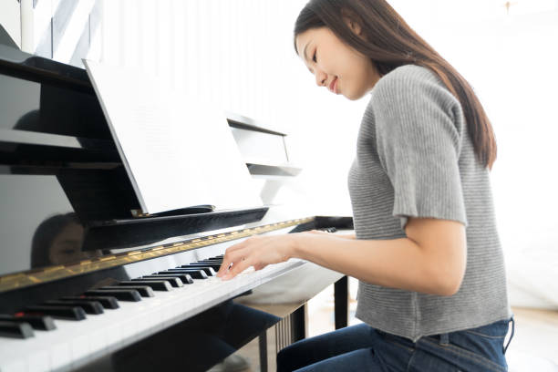 Portrait Asian woman playing  playing piano stock photo