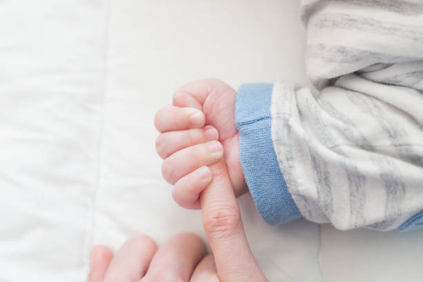 istock baby hand and mother 1157576722