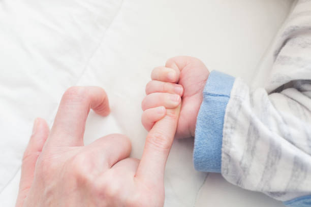 istock baby hand and mother 1157576723