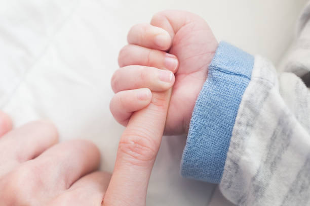 istock baby hand and mother 1157576724