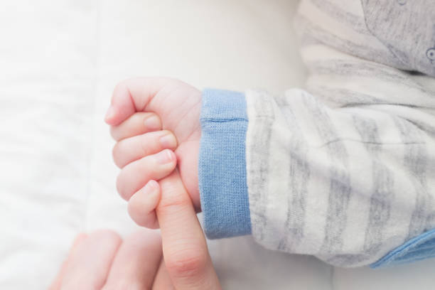 istock baby hand and mother 1157576725