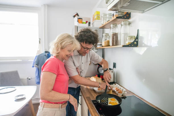 istock Happy senior couple preparing eggs for breakfast in the kitchen 1157579097