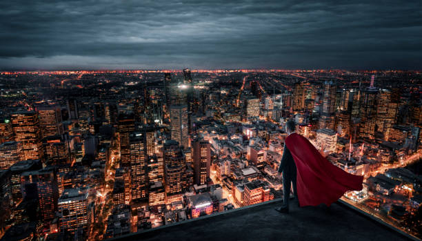 geschäftsmann mit rotem umhang steht nachts auf dem dach über der stadt - roof men business city stock-fotos und bilder