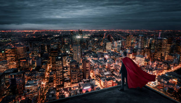 hombre de negocios con capa roja de pie en la azotea sobre la ciudad por la noche - roof men business city fotografías e imágenes de stock