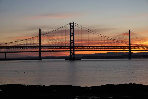istock Midsummer sunset behind road Bridges over the Forth 1157580120