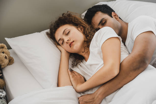 istock a man and a woman lying on a bed 1157580555