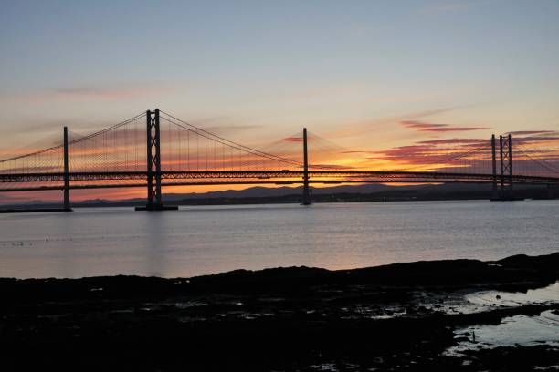 istock Midsummer sunset behind road Bridges over the Forth 1157582709