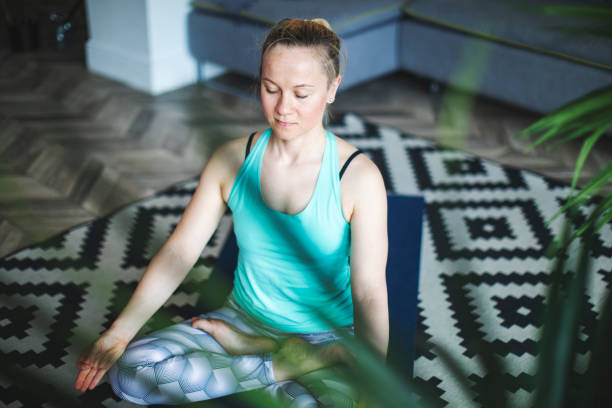 istock Woman practicing yoga at home 1157584796