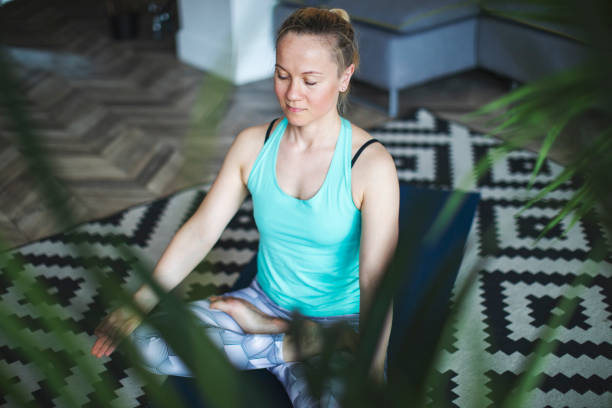 istock Woman practicing yoga at home 1157585784
