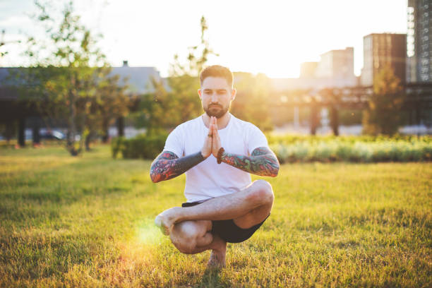 istock Tattooed man practicing yoga outdoors 1157589531