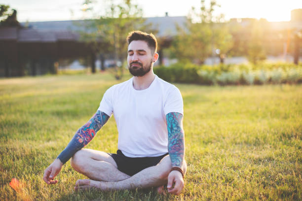 istock Tattooed man practicing yoga outdoors 1157590486